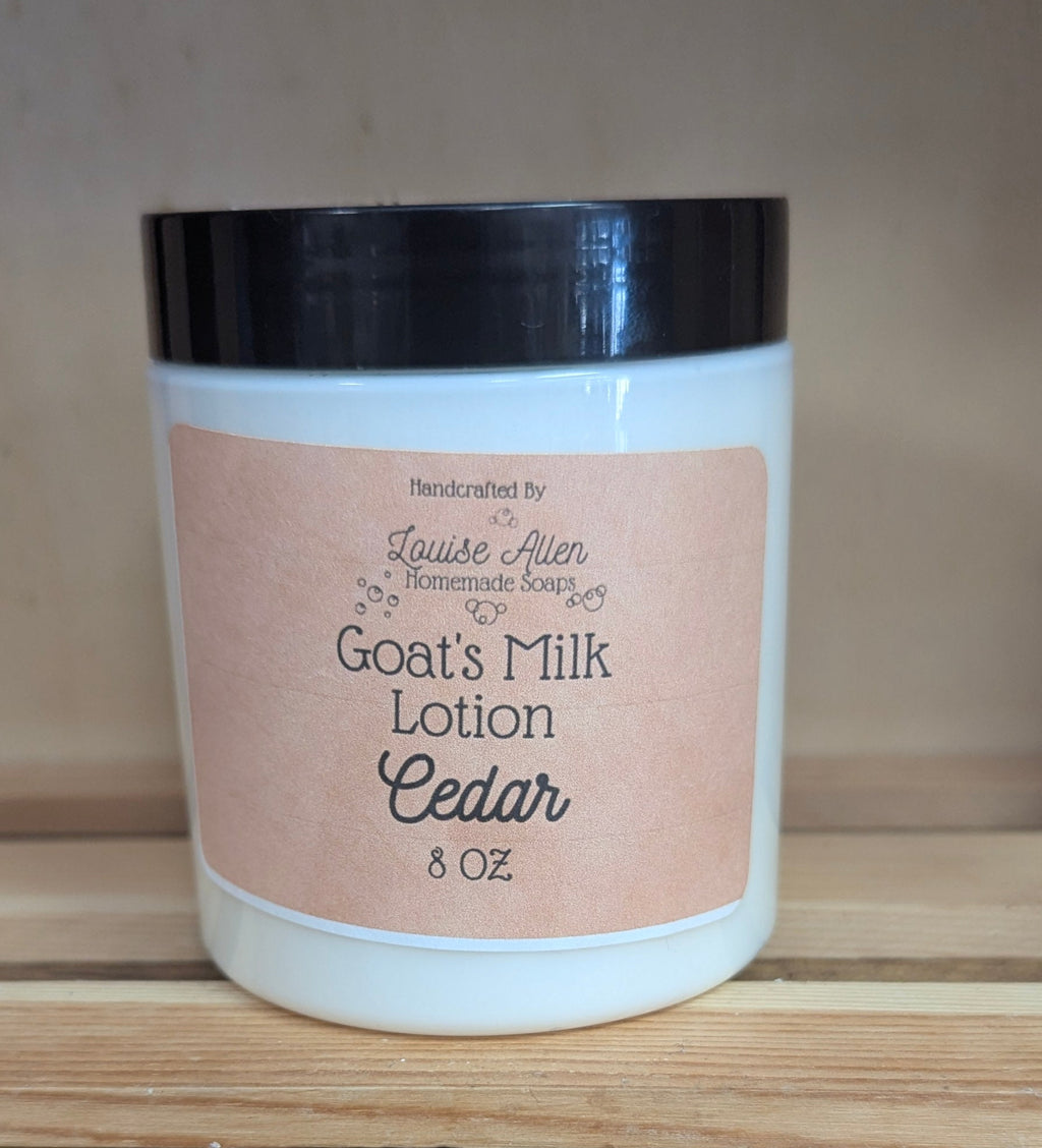 Jar of goat's milk lotion labeled 'Cedar' on a wooden surface