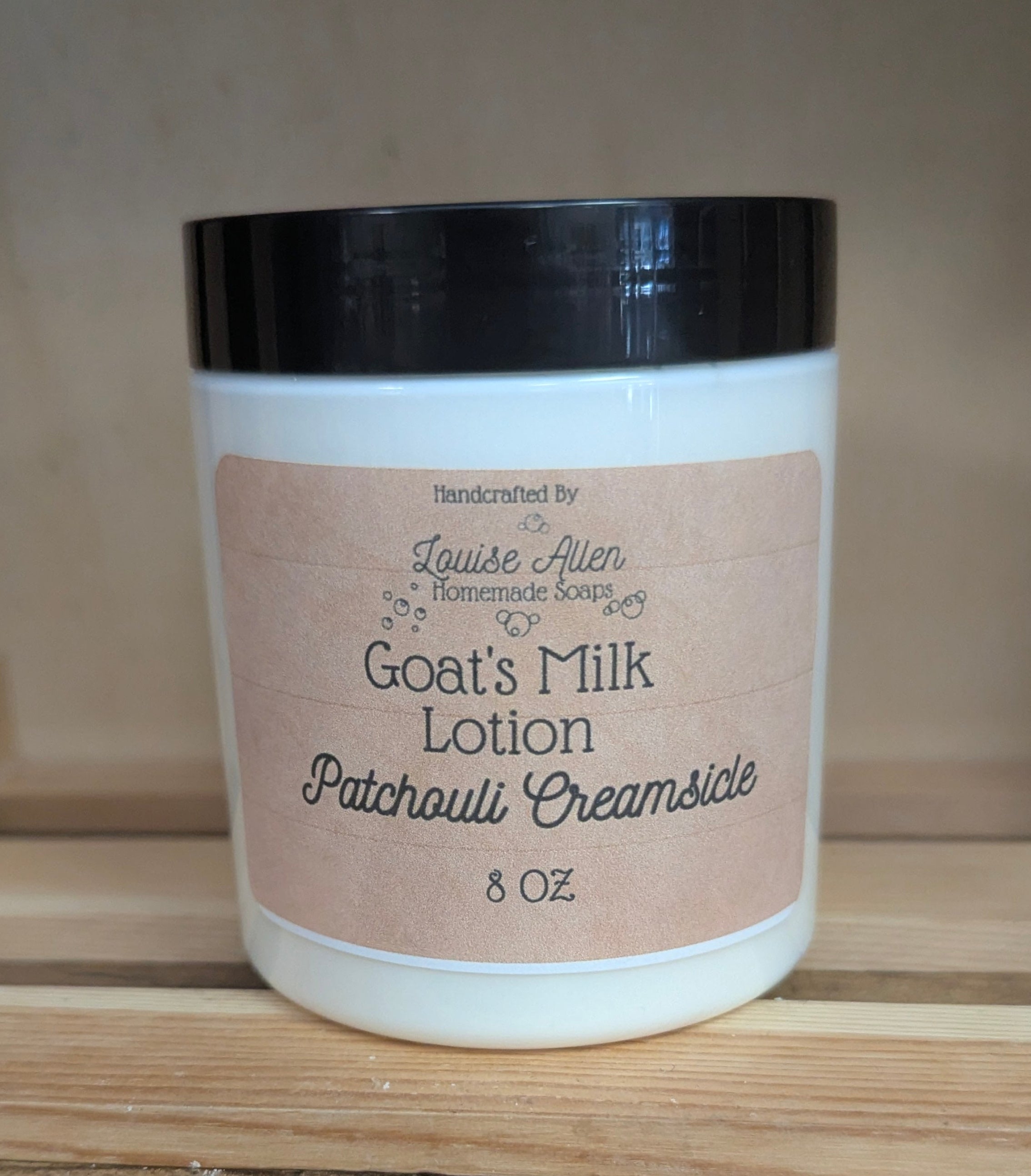 Goat's Milk Lotion jar labeled 'Patchouli Dreamsicle' on a wooden surface