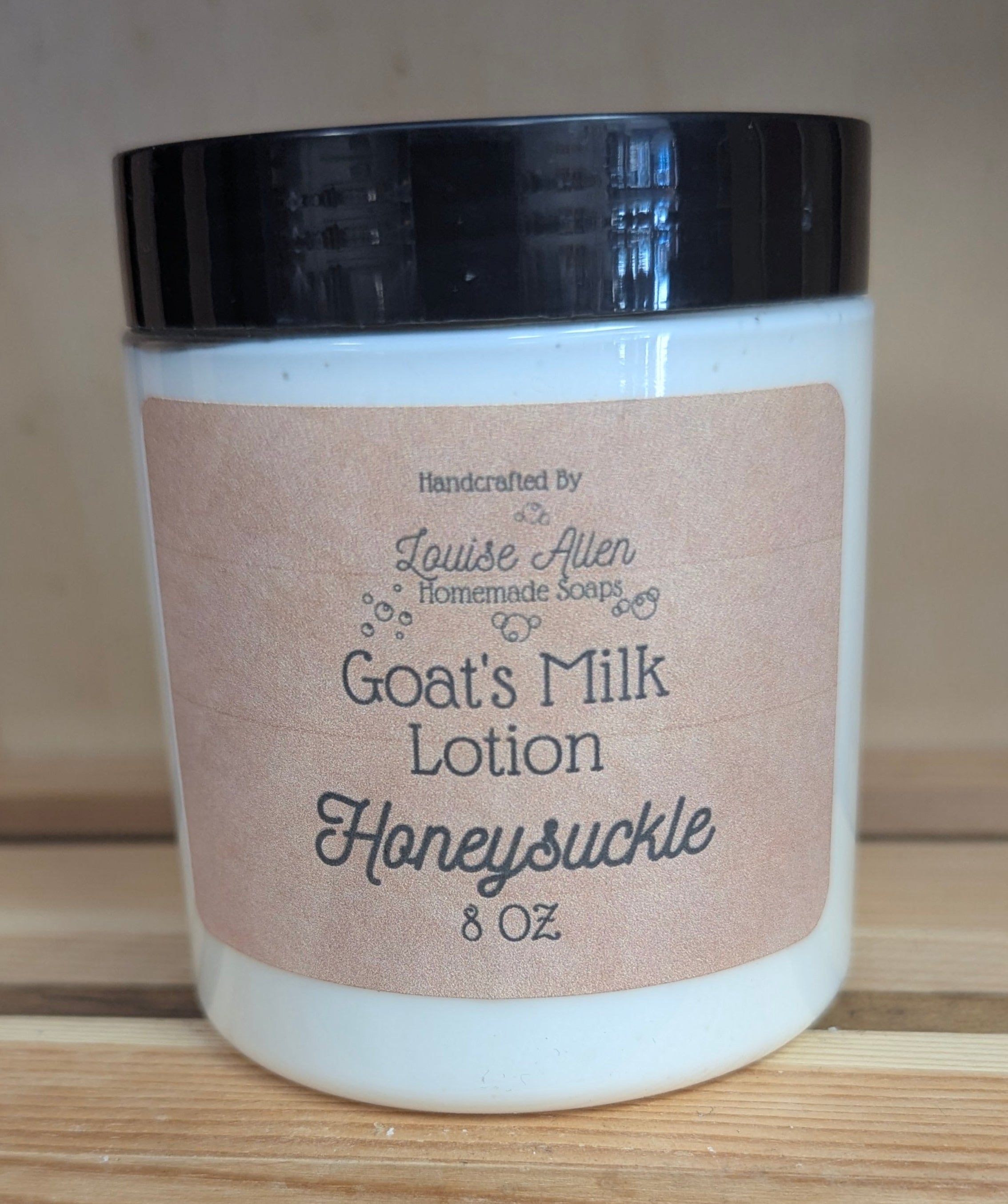 Goat's Milk Lotion Honeysuckle jar on a wooden surface