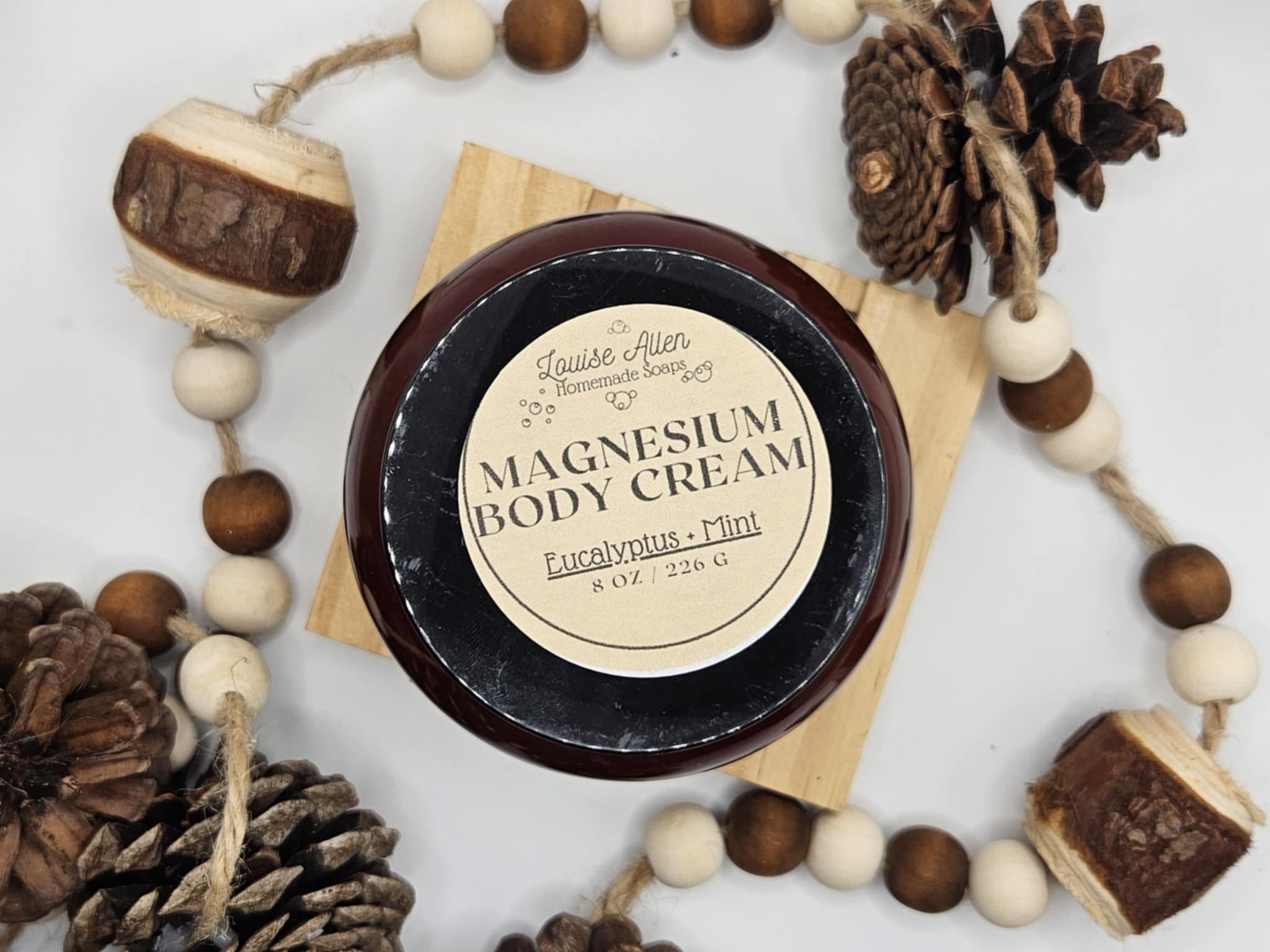 Jar of magnesium body cream with decorative elements on a light background